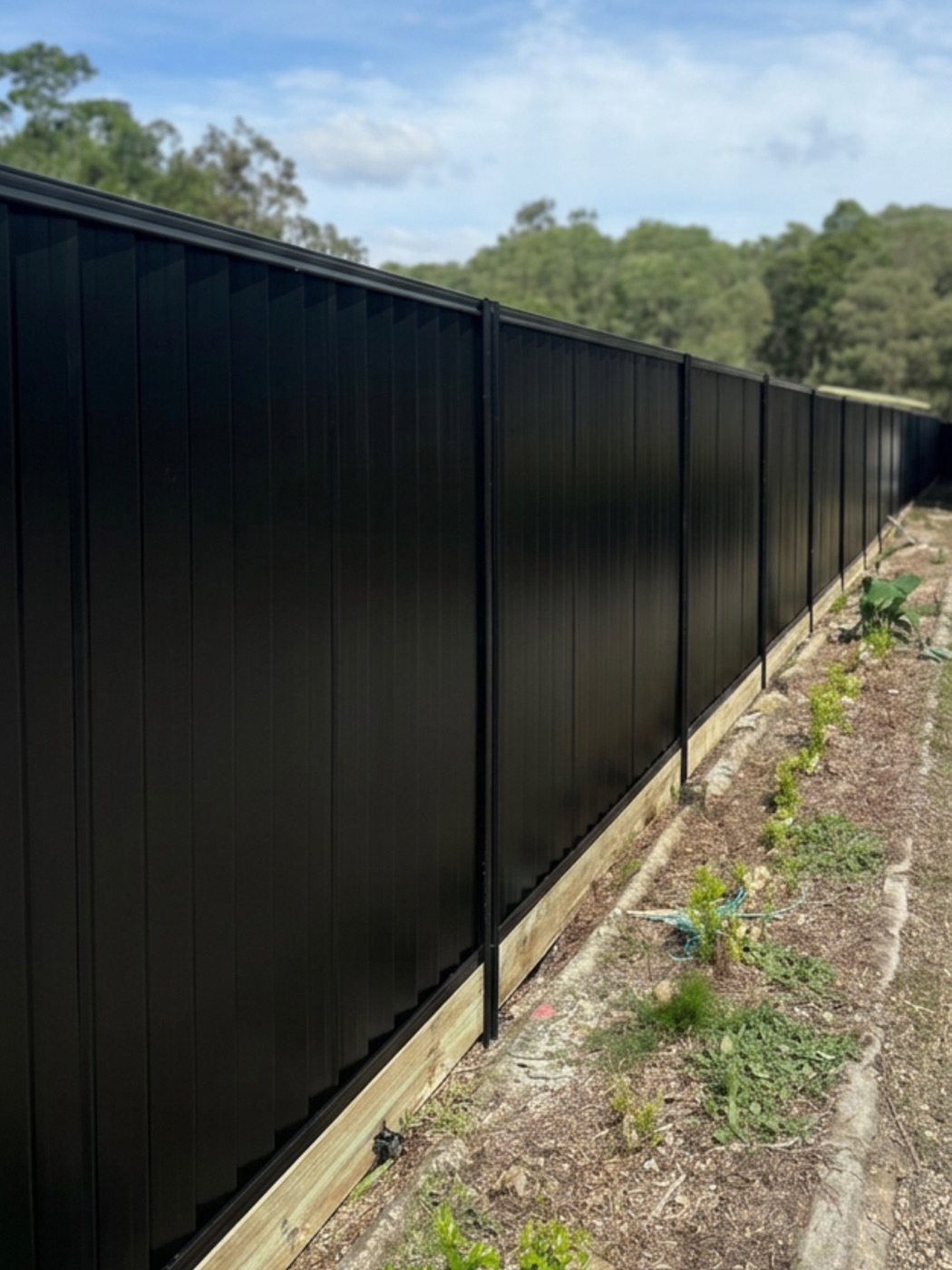 Long Colorbond fence in Monument colour, built by CoasTrade on the Sunshine Coast